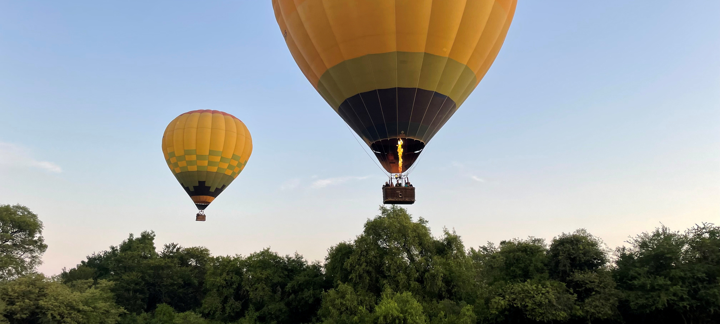 This is an image of two Hot Air Balloons taking off from Sun Catchers Launch Site. The sunrise is visible in the background.